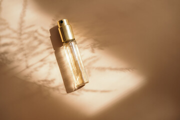Small perfume golden bottle on warm pastel - 395098252