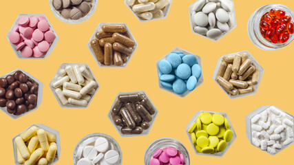 Medical capsules and pills in hexagonal jars on yellow background