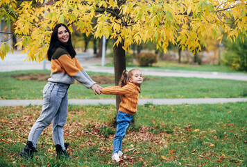 Fototapeta premium mom and daughter are walking in the autumn park