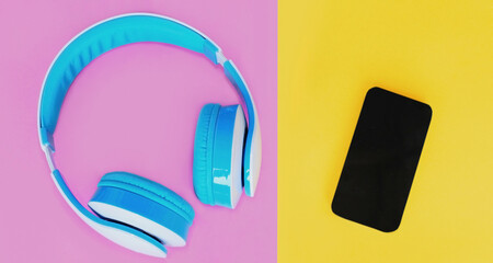 Close up of blue headphones and smartphone over colorful pink background