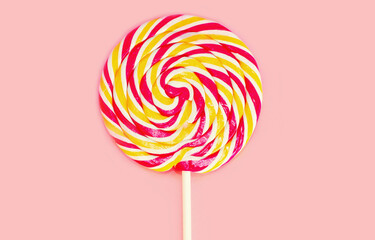 Close up image of colorful lollipop isolated on a pink background