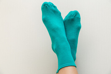 woman in green socks on a light beige background