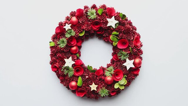 Top view of a large Christmas Wreath made with red ornaments placed on white plain background