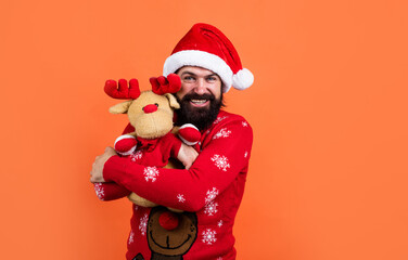 happy bearded man in santa claus hat and knitted sweater with toy celebrate new year winter holiday, christmas gift