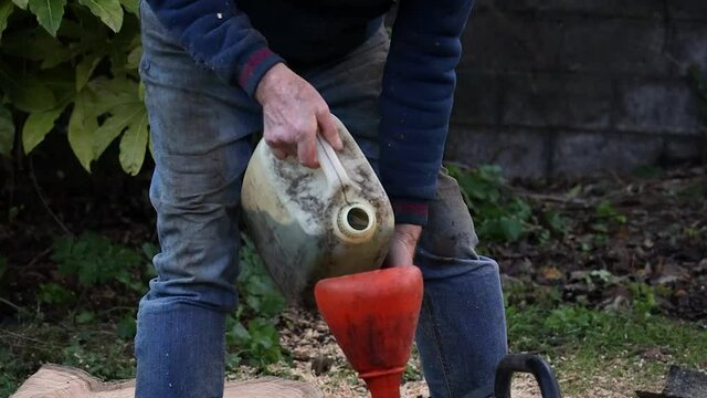 Man Pouring Petrol Into a Funnel in Slow Motion