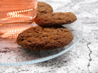 Homemade chocolate brown butter cookies on a transparent saucer and dogwood compote.