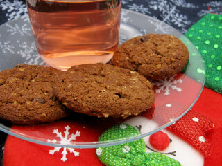 Homemade chocolate brown butter cookies on a transparent saucer and dogwood compote on a Christmas background. New Year.