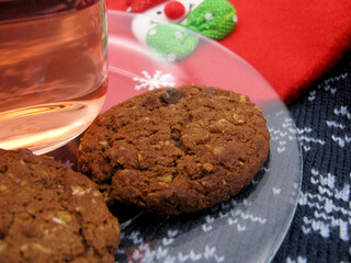 Homemade chocolate brown butter cookies on a transparent saucer and dogwood compote on a Christmas background. New Year.