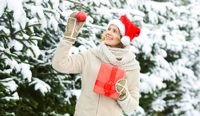 Bright memories. lady red santa hat at fur tree. winter nature forest covered with white snow. bright weather is prefect mood. happy woman hold xmas present box. girl with christmas tree decoration