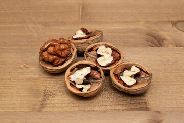 Tasty brown walnuts on wood background. Opened and not disclosed