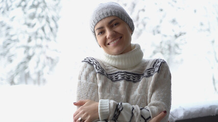 Portrait of beautiful smiling brunette woman weraring knitted nordic print sweater in winter scenery 