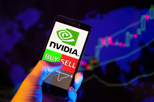 Company logo NVIDIA on smartphone screen, hand of trader holding mobile phone showing BUY or SELL on background of stock chart. Russia, Stavropol, - May 25, 2019