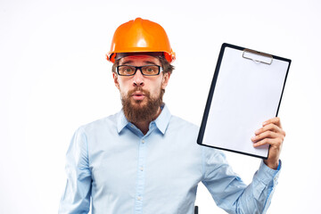 A man in an orange hard hat with documents Industrial activity work