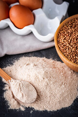 fresh natural buckwheat flour on a dark stone background culinary concept