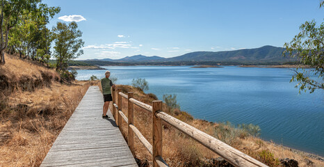Obraz premium Walkway with railing towards the edge of a reservoir, focus on the horizon