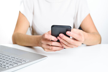 hands of an unrecognizable caucasian woman using an smart phone in the office. Concept of new technologies and distraction