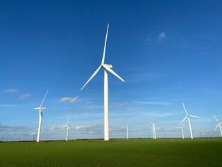 Wind farm turbines that produce electricity energy. Windmill Wind power technology productions Wind turbines standing in green field - stock footage