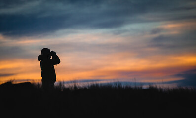 silhouette of a person with binoculars