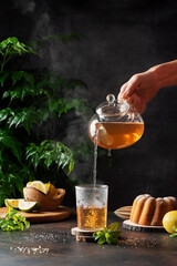 Woman hand pourung a hot black tea