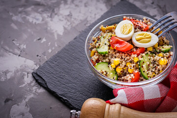 bowl of healthy quinoa with vegetables on a dark rustic background
