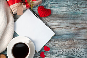 Notepad with coffee and a gift in a cozy, romantic atmosphere. The view from the top. Concept of February 14, love.