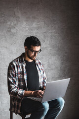 Casual man with laptop over gray background. internet, education, teleworking