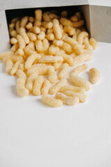 Corn sticks in paper box scattered on a white background. Top view. Place for your text