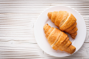 delicious fresh croissant on a white wooden rustic background