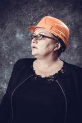 Middle-aged woman construction superintendent in helmet studio portrait.