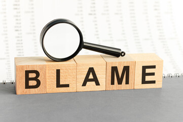 Wooden Blocks with the text: blame with magnifying glass.