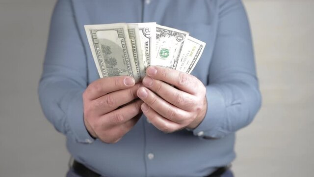 man holding in hands a fan of american dollars close-up