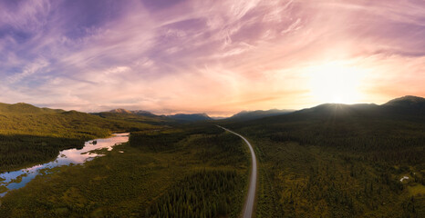 Picturesque Panoramic View of Scenic Highway surrounded by Golden Rocky Mountains at Sunset in Canadian Nature. Aerial Drone Shot. Alaska Highway, near Tagish, Southern Yukon, Canada.