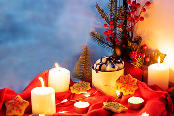 Winter Christmas holidays background with candles; christmas light; Cup of cocoa with marshmallow or hot chocolate near a window