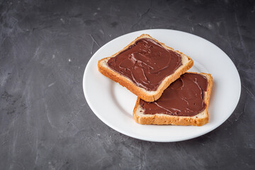 toasts with chocolate butter on a dark stone background