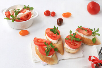 Caprese Bruschetta toast with mozzarella cheese, cherry tomatoes and fresh garden Basil.Traditional Italian food, healthy natural Breakfast, cholesterol-free and GMO-free, space for text