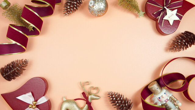 Luxury Christmas background with on trend fashionable stylish coral, deep red and gold gifts and decorations. Top view blog hero header creative composition flat lay with negative copy space.