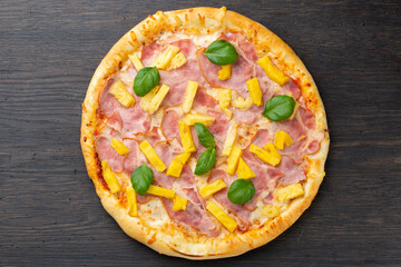 Italian pizza with melted mozzarella cheese, olives and sausage garnished with fresh vegetables and basil leaves