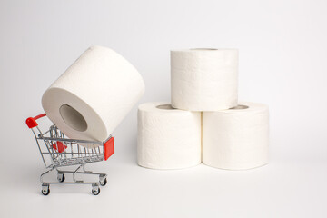 Roll of toilet paper in a toy trolley on a white background. Close-up. Panic purchase of toilet paper during quarantine.