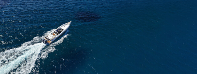 Aerial drone photo of luxury inflatable speed boat cruising in deep blue Aegean sea, Mykonos island, Cyclades, Greece