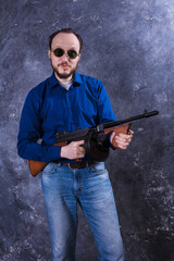 Mature man in sunglasses with tommy gun