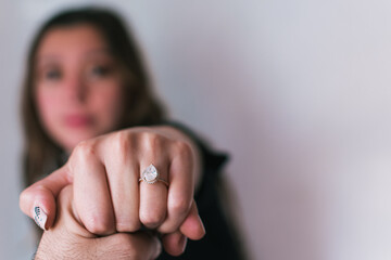 A woman's hand showing her engagement ring on a blurry background. A wedding ring on hand 