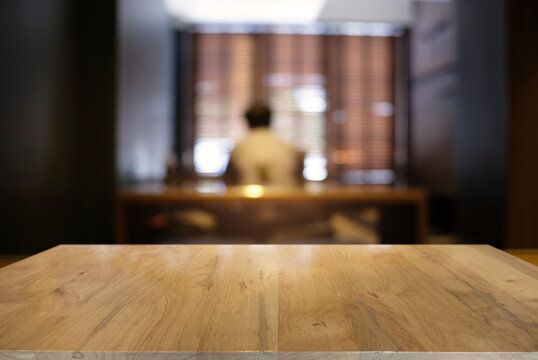 Wooden Table In Room With Man In Background