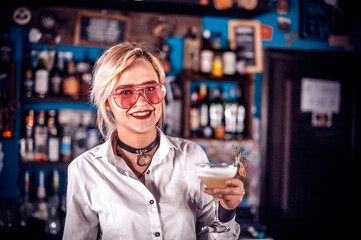 Girl bartender creates a cocktail in the public house