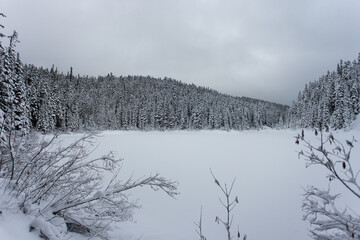 hiker in snow capped mountains and icy lake