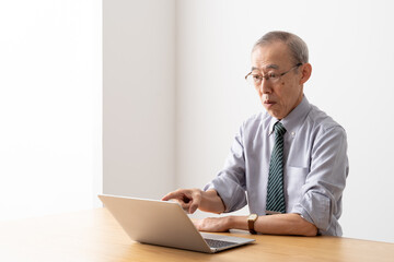 パソコンでオンライン会議をするシニアビジネスマン