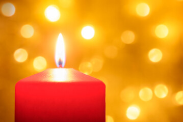 Close up of a lit red  Christmas candle with defocused lights in background. Bokeh effect and copy space.