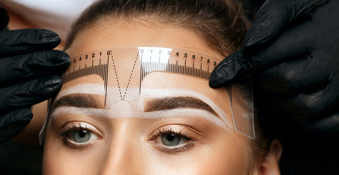Measuring of eyebrows with ruler before permanent makeup