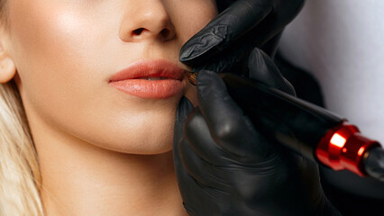 Beauty specialist applying lip tattoo