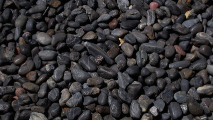 Black Pebbles close up macro detail round river bed drift rock flatlay background dark moody