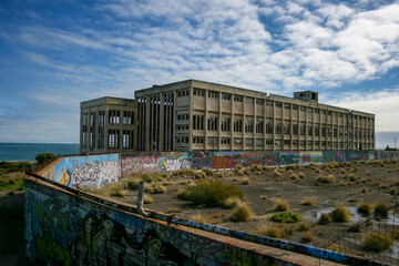 Obraz premium Old Power Station in Fremantle with graffiti on sunny day with blue sky and some clouds, next to the beach, lost places, Perth, Western Australia